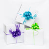White gift box with purple ribbon, white gift box with green ribbon and white gift box with blue ribbon